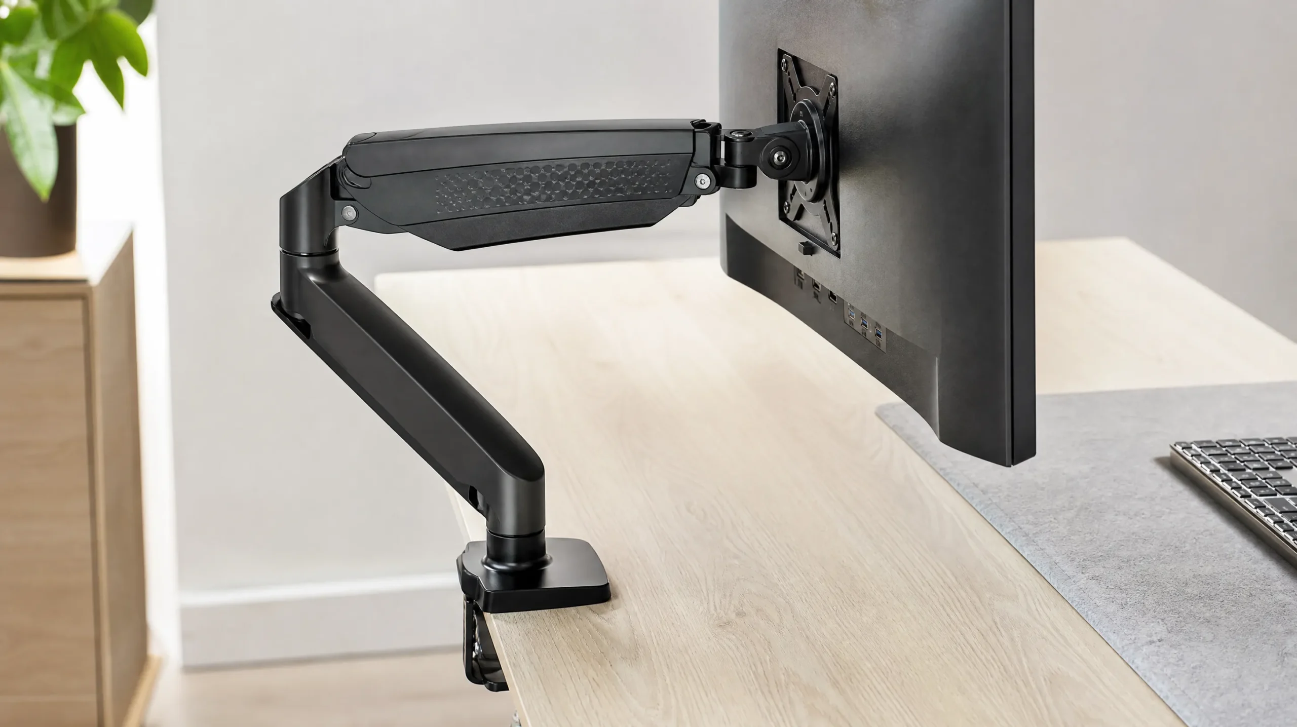 Ideal Monitor Height: How High Should Your Monitor Be? (2026 Guide) 5 Ergonomic monitor arm clamped to desk showing adjustable height positioning as a solution for incorrect monitor height